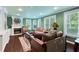 Bright living room with hardwood floors, fireplace, built-in shelving, and three sunny windows overlooking mature landscaping at 190 Winford Close, Duluth, GA 30097