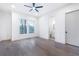 A modern, light-filled bedroom features hardwood floors, a ceiling fan, and access to an en-suite bathroom at 240 Grogans Lake Pt, Sandy Springs, GA 30350