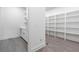 Walk-in pantry featuring white cabinets and shelving, and hardwood floors at 240 Grogans Lake Pt, Sandy Springs, GA 30350