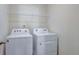 Convenient laundry room featuring white washer, dryer, and overhead storage at 2710 Serena Way, South Fulton, GA 30331