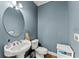 Stylish powder room with pedestal sink, oval mirror, and modern fixtures at 1265 Emerald Se Ave, Atlanta, GA 30316