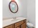 Bright bathroom featuring a single sink vanity with wood cabinets and a decorative mirror at 1536 Baxley Pine Trce, Suwanee, GA 30024