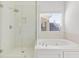 Bright bathroom featuring a glass shower and separate tub with tile surround at 1536 Baxley Pine Trce, Suwanee, GA 30024