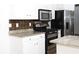 Charming kitchen features stainless steel appliances, granite countertops, and white cabinets at 1630 Versailles Dr, Atlanta, GA 30331