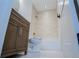 Bathroom with a wood vanity, mirror, toilet, and tub with tiled walls at 279 Laura Cir, Bowdon, GA 30108