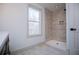 Modern bathroom with a tile shower, glass door, and bright window at 279 Laura Cir, Bowdon, GA 30108