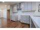 A well-lit kitchen features white cabinets, a stainless steel range hood, subway tile backsplash, and gleaming hardwood floors at 279 Laura Cir, Bowdon, GA 30108