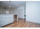A kitchen island with white cabinetry, an undermount sink, and stainless steel pull-down faucet, complemented by hardwood floors at 279 Laura Cir, Bowdon, GA 30108