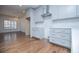 Bright kitchen featuring white cabinets, stainless steel range hood, and hardwood floors, creating a modern and inviting space at 279 Laura Cir, Bowdon, GA 30108