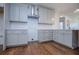 A modern kitchen boasts white cabinetry, a stainless steel range hood, subway tile backsplash, and rich hardwood floors at 279 Laura Cir, Bowdon, GA 30108