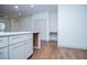 Kitchen island featuring white cabinets, an undermount sink, stainless steel pull-down faucet, and hardwood flooring, creating a functional space at 279 Laura Cir, Bowdon, GA 30108
