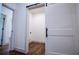 Laundry room with hardwood floors, neutral paint and a sliding barn door at 279 Laura Cir, Bowdon, GA 30108