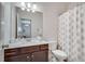 Bathroom with single sink vanity, toilet, mirror and patterned shower curtain at 5242 Park Vale Dr, Sugar Hill, GA 30518