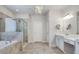 Bathroom features a glass shower, soaking tub, chandelier, and double sinks at 5242 Park Vale Dr, Sugar Hill, GA 30518