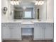 Elegant primary bathroom featuring a chandelier, framed mirror, and double vanity at 5242 Park Vale Dr, Sugar Hill, GA 30518
