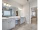 Bright bathroom featuring double vanity, tiled floor, and an open doorway to the primary bedroom at 5242 Park Vale Dr, Sugar Hill, GA 30518