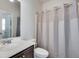 Bathroom with a single sink vanity, toilet and a patterned shower curtain at 5242 Park Vale Dr, Sugar Hill, GA 30518