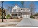 Charming two-story home with a three-car garage, manicured lawn, and inviting front porch at 5242 Park Vale Dr, Sugar Hill, GA 30518