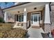 Inviting front porch with seating area, brick columns, and a well-manicured landscape at 5242 Park Vale Dr, Sugar Hill, GA 30518