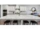 Bright kitchen featuring a large granite island with seating, white cabinetry, and modern stainless steel appliances at 5242 Park Vale Dr, Sugar Hill, GA 30518