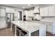Spacious white kitchen with a large island, stainless steel appliances, and hardwood floors offers a modern design at 5242 Park Vale Dr, Sugar Hill, GA 30518