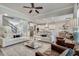 Spacious living room featuring hardwood floors, white couches, ceiling fan, and open layout to kitchen at 5242 Park Vale Dr, Sugar Hill, GA 30518