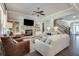 Cozy living room with fireplace, built-in shelving, ceiling fan, and open layout to foyer at 5242 Park Vale Dr, Sugar Hill, GA 30518