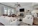 Cozy living room featuring a stone fireplace, hardwood floors, built-in bookshelves, and large windows at 5242 Park Vale Dr, Sugar Hill, GA 30518