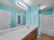 Bright teal bathroom with vanity, large mirror, and a shower and tub combo at 520 Ballyshannon Dr, Dacula, GA 30019