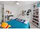 Bright bedroom with a ceiling fan, window and blinds, shelf, bed and a desk at 520 Ballyshannon Dr, Dacula, GA 30019