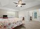 Bedroom showcasing carpet floors, ceiling fan, a view to the exterior, and access to the bathroom at 520 Ballyshannon Dr, Dacula, GA 30019