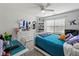 Bright bedroom with a ceiling fan, window and blinds, shelf, bed and a desk at 520 Ballyshannon Dr, Dacula, GA 30019