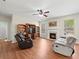 Cozy living room with hardwood floors, ceiling fan, fireplace, and built-in shelving at 520 Ballyshannon Dr, Dacula, GA 30019