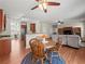 Open-concept living room with wood floors, ceiling fan, kitchen bar, and adjacent breakfast nook at 520 Ballyshannon Dr, Dacula, GA 30019