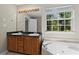 Bright bathroom with large vanity with double sinks, bathtub, and large window for natural light at 74 Rotunda Ct, Dallas, GA 30157