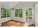 Bright breakfast nook features hardwood floors, charming light fixture, and views of the outdoor deck and lush yard at 74 Rotunda Ct, Dallas, GA 30157