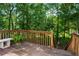 Wooden deck with railing and bench seating, overlooking a green, lush, wooded landscape at 74 Rotunda Ct, Dallas, GA 30157