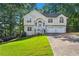 Charming two-story home with a well-manicured lawn, attached two-car garage, and classic architectural details at 74 Rotunda Ct, Dallas, GA 30157