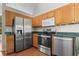 Well-equipped kitchen with stainless steel appliances, wooden cabinets, and green countertops at 74 Rotunda Ct, Dallas, GA 30157