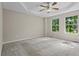 Spacious primary bedroom with tray ceiling, ceiling fan, and large windows showcasing wooded views at 74 Rotunda Ct, Dallas, GA 30157
