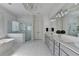 Light-filled bathroom with a glass-enclosed shower, a soaking tub, and dual sink vanities at 2892 Darlington Run, Duluth, GA 30097