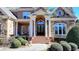 A stunning home showcasing a brick and stone exterior, arched doorway, and meticulously maintained landscaping at 2892 Darlington Run, Duluth, GA 30097