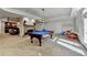 Game room featuring a pool table, stone fireplace, and walk-out to backyard for easy entertainment access at 2892 Darlington Run, Duluth, GA 30097