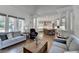 Open-concept living room with a view into the kitchen and large windows overlooking the yard at 2892 Darlington Run, Duluth, GA 30097