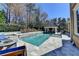 A backyard pool with a sun shelf, jacuzzi and a large patio area with a covered grill at 2892 Darlington Run, Duluth, GA 30097