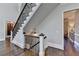 Elegant staircase with dark wood floors, decorative iron railing, and view of the foyer and hallway at 2892 Darlington Run, Duluth, GA 30097