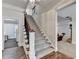 This carpeted staircase features dark wood trim and wrought iron spindles and overlooks the finished basement at 2892 Darlington Run, Duluth, GA 30097
