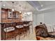 Wet bar area with dark wood cabinetry, seating, and wine storage, perfect for entertaining guests at 2892 Darlington Run, Duluth, GA 30097