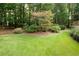 Well-maintained backyard featuring a verdant lawn and landscaped garden beds at 3045 Camp Branch Rd, Buford, GA 30519