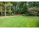 Manicured lawn and wooded perimeter offers privacy and natural beauty at 3045 Camp Branch Rd, Buford, GA 30519